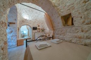 een slaapkamer met een bed in een stenen muur bij Trullo Lauro in Ceglie Messapica