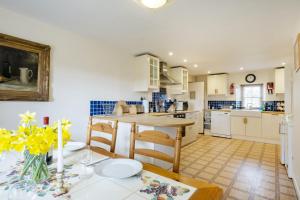 a kitchen and dining room with a table and chairs at White Lodge Haughton Castle 2 in Hexham +5 photos