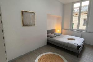 ein kleines Schlafzimmer mit einem Bett und einem Fenster in der Unterkunft - Meublés de Beaulieu cœur de ville - in Angoulême