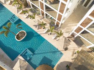 - une vue sur la grande piscine bordée de palmiers dans l'établissement Acqua di Mare Resort, à West Bay