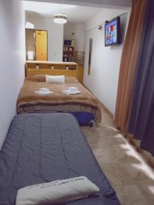 sypialnia z dwoma łóżkami i telewizorem w obiekcie Los Tatas ,departamento w mieście Purmamarca