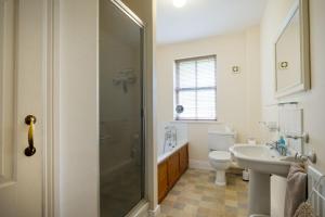 a bathroom with a shower and a toilet and a sink at Garden Cottage Haughton Castle in Hexham
