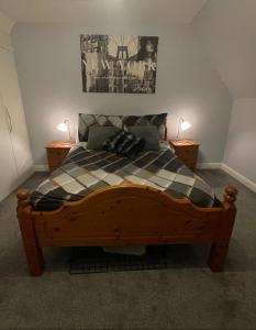 a bedroom with a wooden bed with a checkered blanket at Beanie’s North Swindon DoubleBed in Blunsdon Saint Andrew