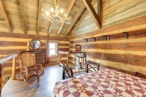 ein Schlafzimmer in einem Blockhaus mit einem Bett und einem Kronleuchter in der Unterkunft Historic Jonesborough Cabin with Fire Pit and Grill! in Jonesborough