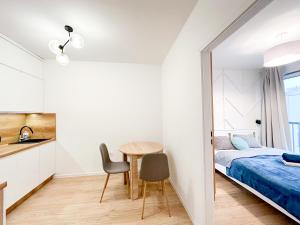 a small bedroom with a bed and a table and chairs at Katowice Centrum Apartament 153 Nova Mikołowska in Katowice