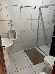 een badkamer met een urinoir en een toilet bij Pousada das Flores. in Boa Vista