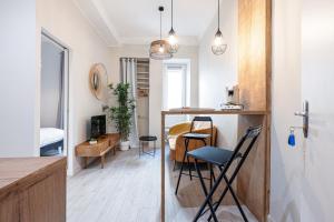 een keuken en een woonkamer met een tafel en stoelen bij Le PETIT JEAN in Nice