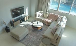 a living room with two couches and a tv at Downtown Oasis, Burj Khalifa Views, Luxury Amenities in Dubai