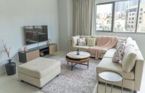 a living room with a couch and a tv at Downtown Oasis, Burj Khalifa Views, Luxury Amenities in Dubai