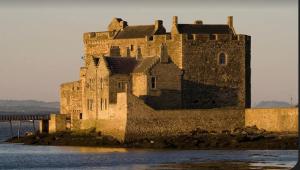 um grande castelo sentado no meio da água em Caledonia House em Rosyth