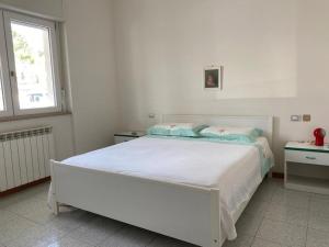 a white bedroom with a white bed and a window at I trabocchi blu in Fossacesia