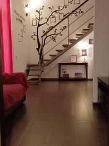 a living room with a staircase with a tree on the wall at Vita Partenopea in Naples