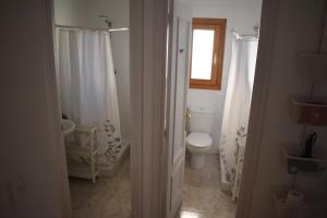 een witte badkamer met een toilet en een raam bij Casa rural La Endrina in Terriente