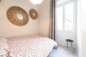 - une chambre avec un lit et un miroir mural dans l'établissement Le PETIT JEAN, à Nice