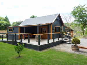 une maison modulaire avec une grande terrasse dans l'établissement Black Cottage Boutique Acommodation, à Havelock North