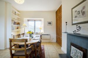 comedor con mesa, sillas y chimenea en Garden Cottage Haughton Castle 2 en Hexham