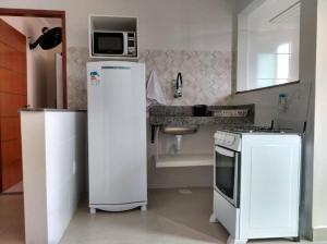 a kitchen with a white refrigerator and a microwave at Apartamento em São Pedro, prédio novo 402 in Juiz de Fora