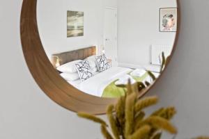 a bedroom with a bed in the reflection of a mirror at The Donkey Shed with Hot tub in Kent