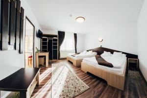una camera d'albergo con due letti e un tavolo di Casa Bradul Voronet a Voronet