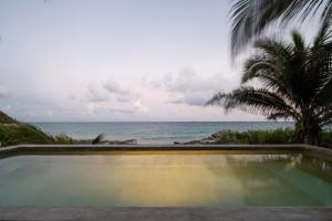 a swimming pool with a view of the ocean at Tropicalito Villa on the Beach in Tulum