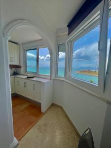 a kitchen with two windows and a view of the ocean at VISTAS ROCA MAR in La Línea de la Concepción