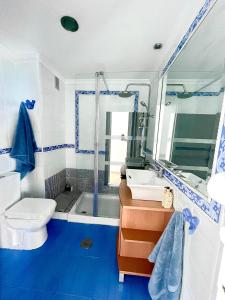 a blue and white bathroom with a toilet and a sink at VISTAS ROCA MAR in La Línea de la Concepción