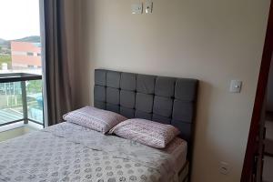 a bedroom with a bed with two pillows on it at Apartamento em São Pedro 305 in Juiz de Fora