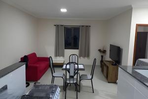 a living room with a table and chairs and a red couch at Apartamento em São Pedro 305 in Juiz de Fora
