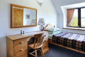 a bedroom with a desk and a bed with a mirror at Red Kite in Belmaduthy