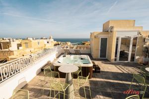 a balcony with a hot tub and a table and chairs at Avalon Boutique in Valletta