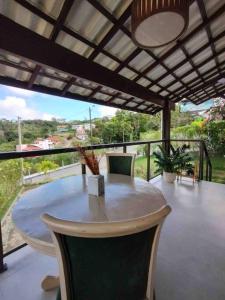 d'une table et de chaises sur un balcon avec vue. dans l'établissement Casa dos Colibris, Lugar memorável!, à Chã Grande