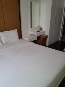 a bedroom with a large white bed and a mirror at Arisara place in Koh Samui 