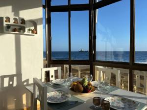 a dining table with a view of the ocean at Pieds dans l'eau - vue sur mer - Playa de Melenara in Melenara