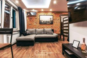 salon z kanapą i ceglaną ścianą w obiekcie Happy - Apartamenty Happy Mielec w Mielcu