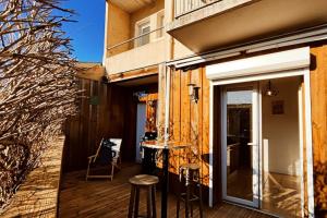 a balcony with a table and stools on a deck at Villa TILLA 110 m2, terrasse babyfoot fléchettes in Arcachon