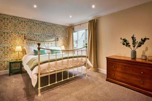 a bedroom with a bed and a dresser and a window at The Old Stables - Hot Tub, Sauna and Cinema in Alyth