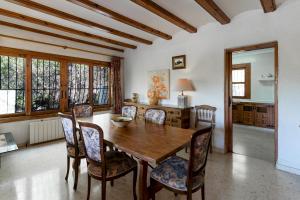 a dining room with a wooden table and chairs at Villa Rosa in Jávea