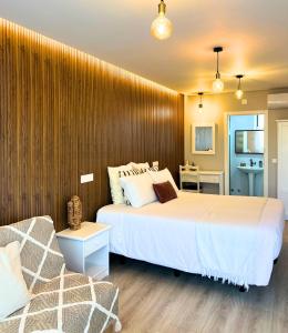 um quarto com uma cama grande e um sofá em Costa Brava Alojamento em Benedita