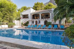 a villa with a swimming pool in front of a house at Villa Rosa in Jávea