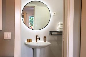 a bathroom with a sink and a mirror at Costa Brava Alojamento in Benedita