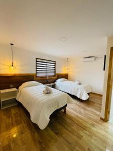 a hotel room with two beds and a window at Residencial Victoria Said in Linares