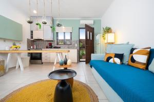 un soggiorno con un divano blu e una cucina di Studio Casa Di Christina a Chania