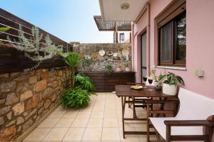 un patio con un tavolo di legno e un muro di pietra di Studio Casa Di Christina a Chania