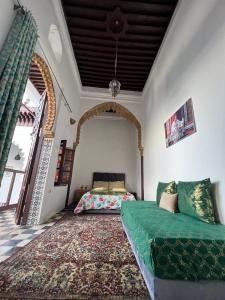 a living room with a green couch and a bed at Riad Palais D'Or in Rabat