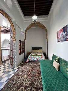 een slaapkamer met een bed en een bank bij Riad Palais D'Or in Rabat