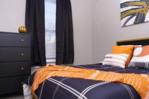 a bedroom with a bed and a dresser and a window at Peaceful Cozy Townhouse in Baltimore