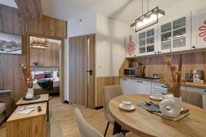 une cuisine et une salle à manger avec une table et des chaises dans l'établissement Apartament z prywatną sauną przy termach Bania, à Białka Tatrzańska