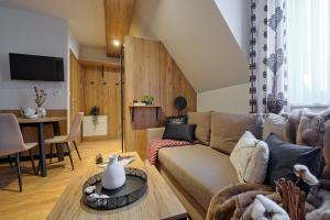 un salon avec un canapé et une table dans l'établissement Apartament z prywatną sauną przy termach Bania, à Białka Tatrzańska