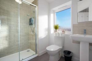 ミルトン・キーンズにあるStunning 4 Bedroom 2 Bathroom House - Close to City Centre - Sleeps 8 - Free Parking, Super-Fast Wifi and Smart TVs by Yoko Propertyのシャワー、トイレ、洗面台を備えたバスルーム