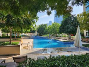 a swimming pool in a park with an umbrella at Downtown Oasis, Burj Khalifa Views, Luxury Amenities in Dubai